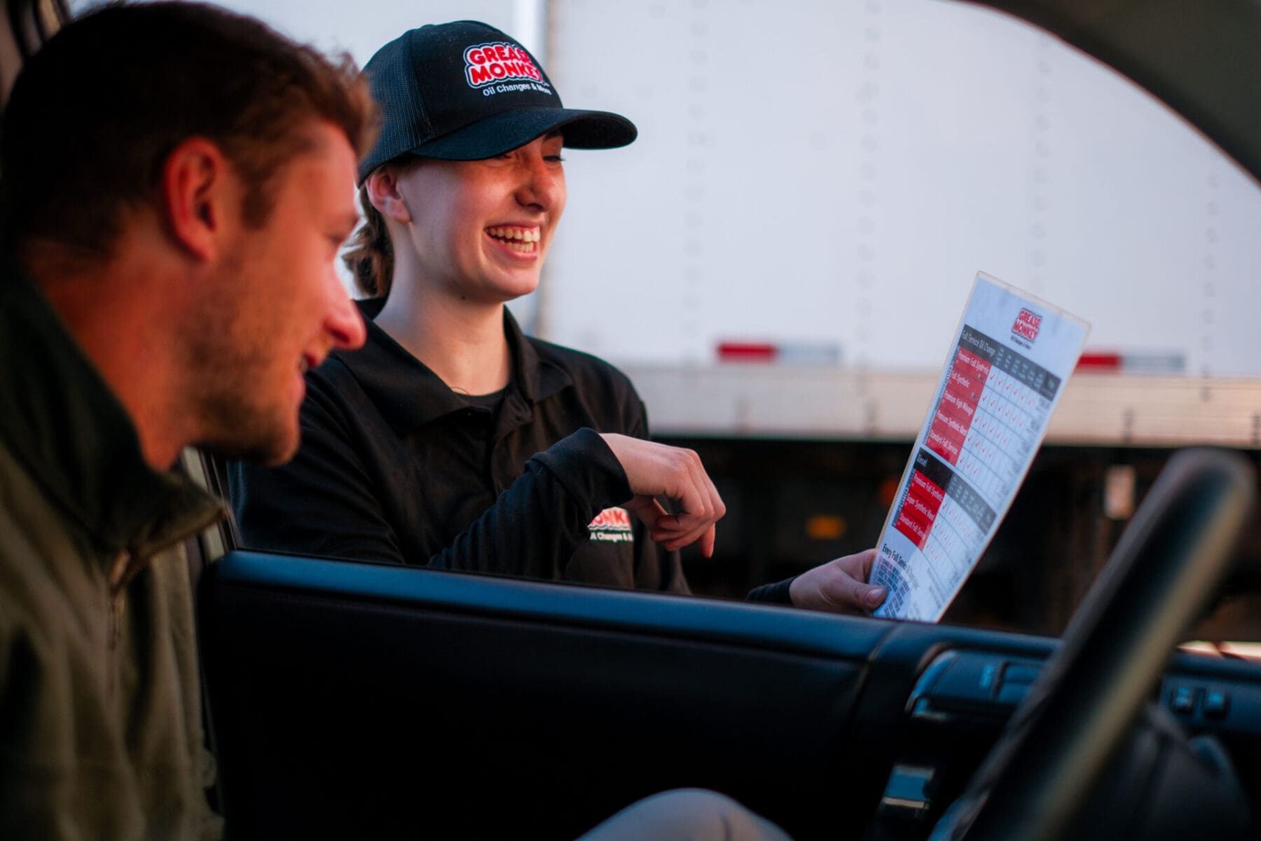 Grease Monkey Technician reviewing services with customer.