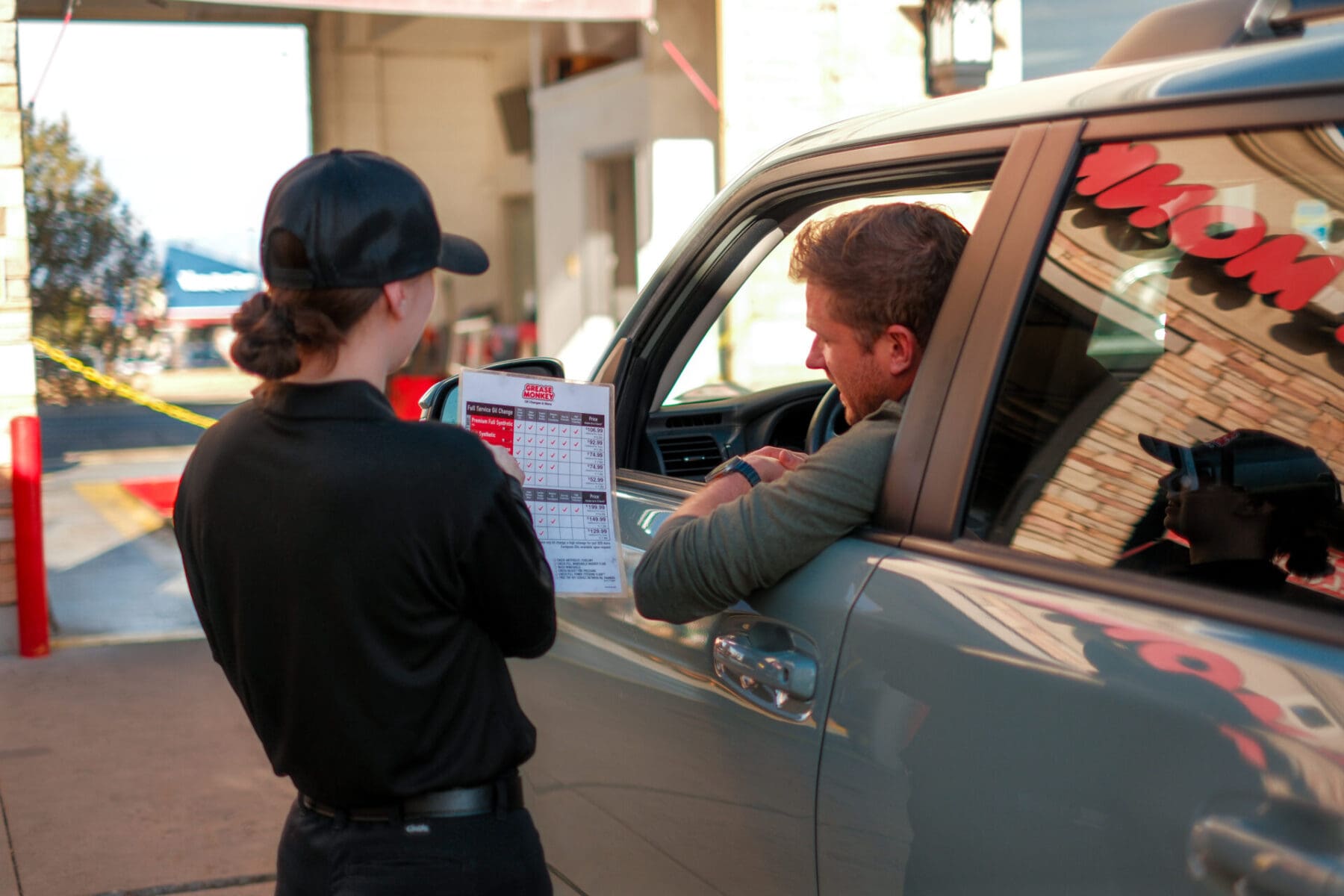 Grease Monkey employee reviewing services with customer.
