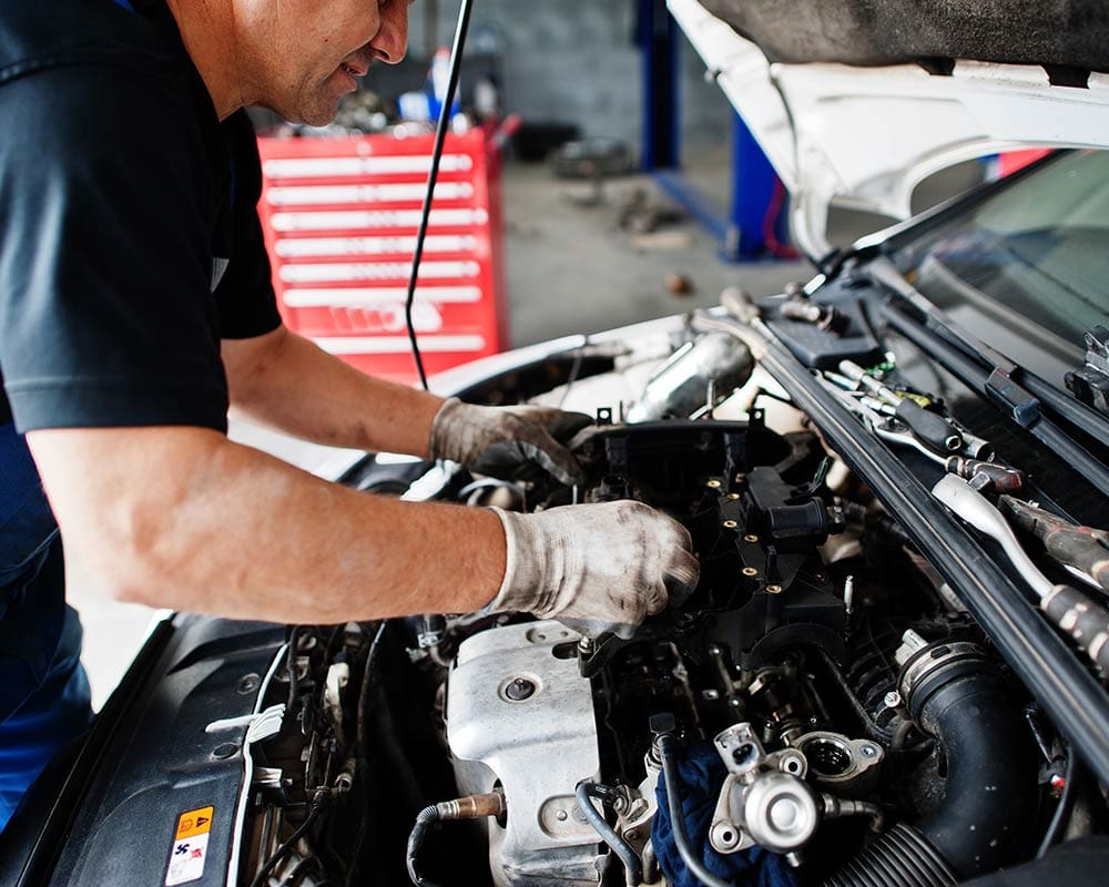 Grease Monkey technician performing routine auto repair service.