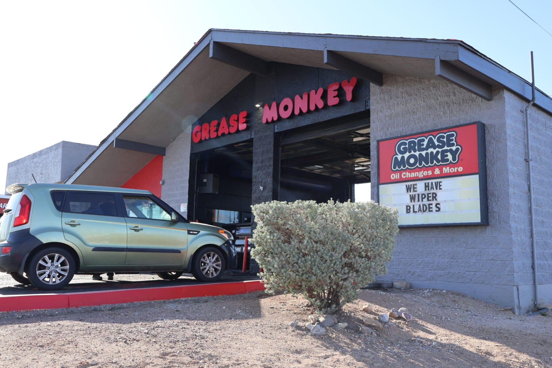 Grease Monkey Oil Change in Tucson shows green car driving into service bay